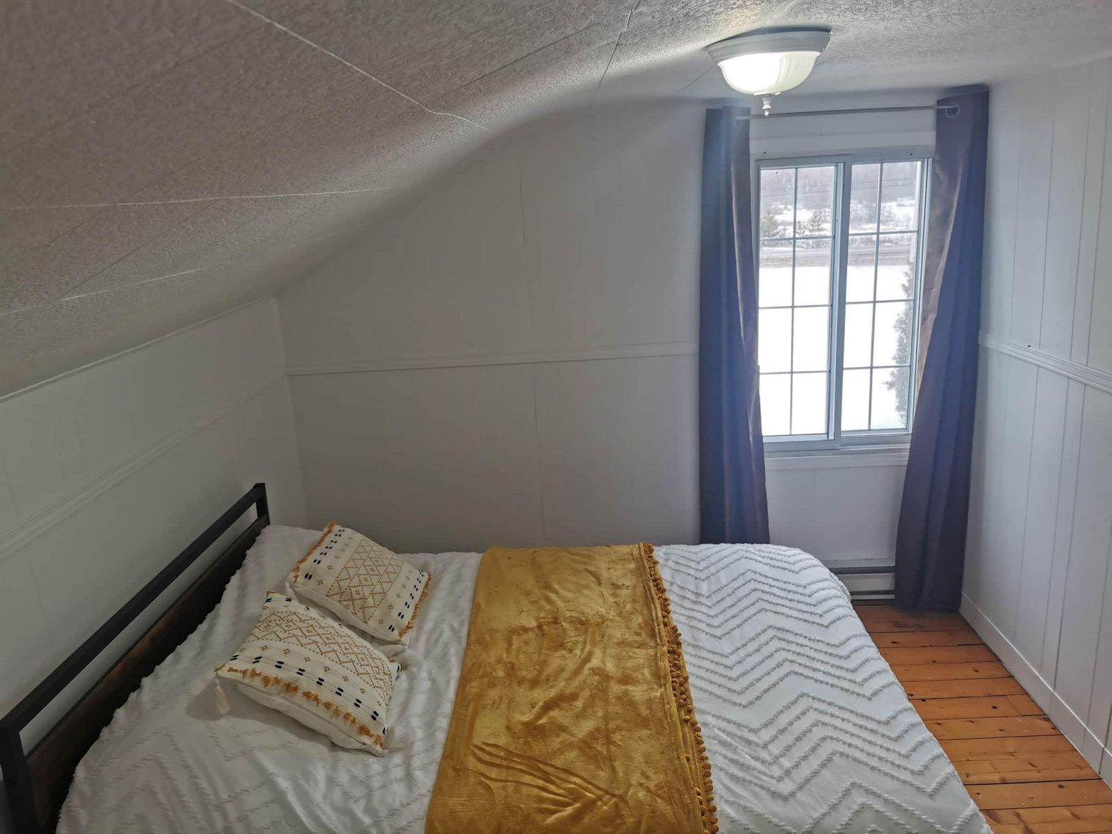 Chambre mansardée à l'étage avec lit double