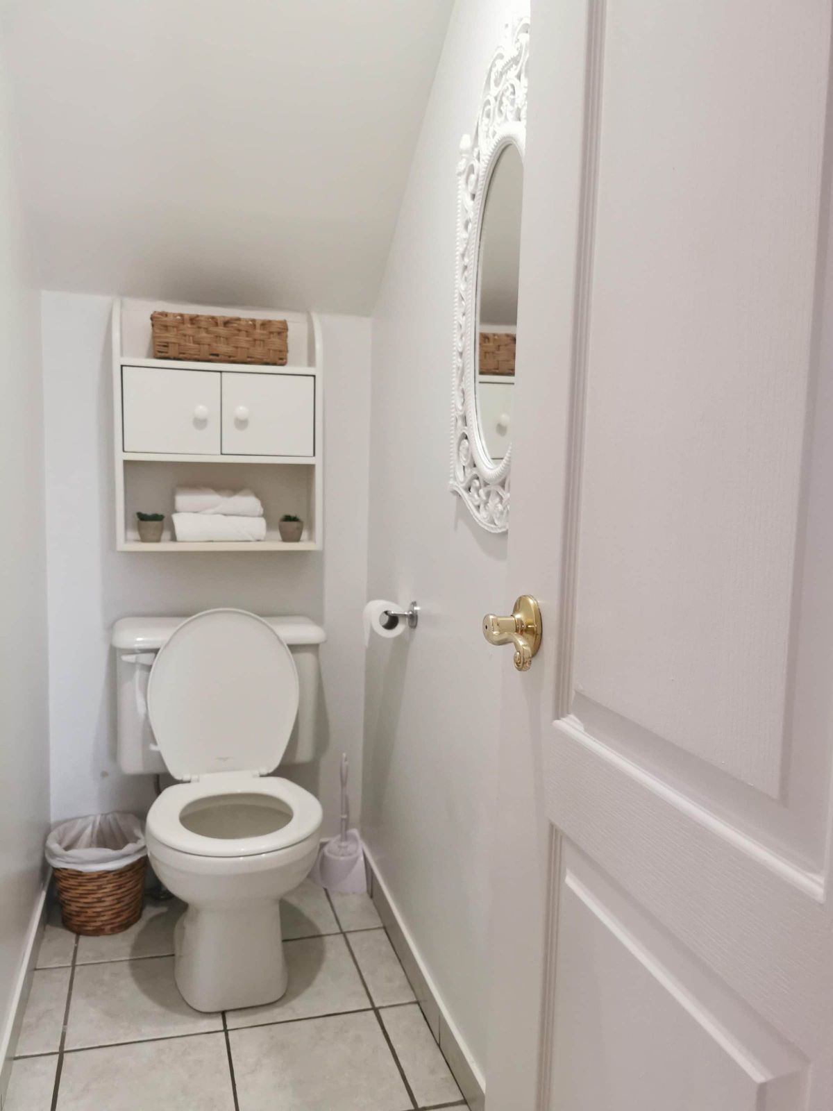 Salle de toilettes avec miroir orné