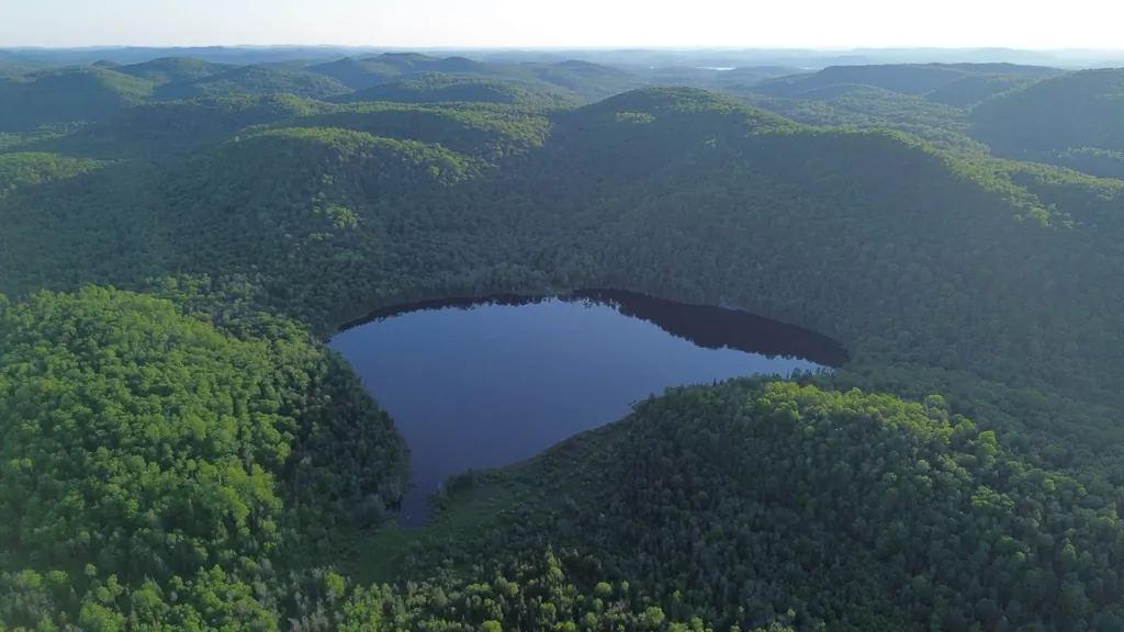 Vue aérienne du lac privé du Chalet Lac Saint-Thomas, entouré de forêt