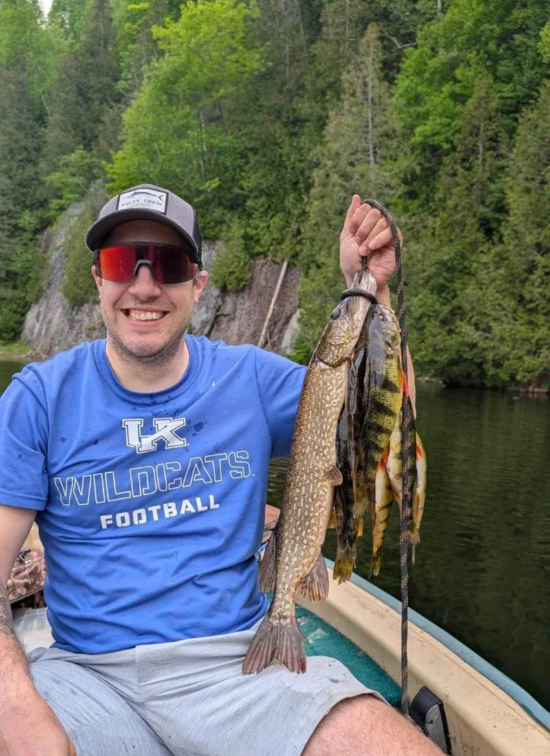 Pêcheur avec brochet et perchaudes au lac privé